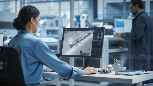 Futuristic Factory Design: Engineer Utilizes Advanced 3d Software to Visualize Robotic Assembly Line. Innovative Manufacturing Concept for Next-generation Production Processes and Smart Automation.