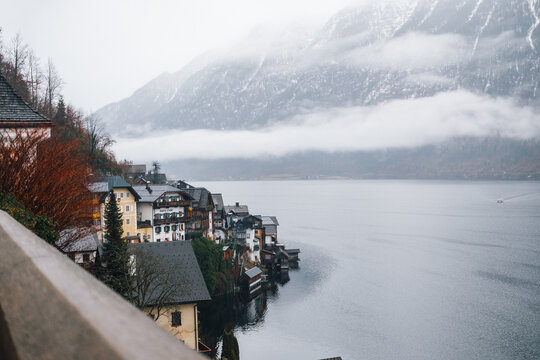 Foggy winter day over Hallstatt village with lakeside buildings and snow-dusted mountains - Powered by Adobe