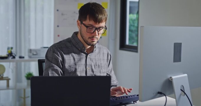 Young adult male freelance developer typing write prompt AI bot app program nomad terminal with coding at office. Artificial intelligence dashboard, robotics, user interface, machine learning concept.