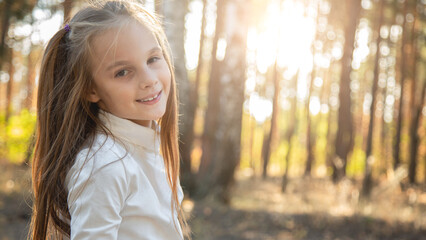 Naklejka premium portrait a pretty girl walking in park in nature at sunset