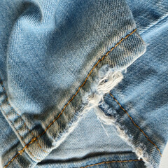 Close-up photography of denim fabric showcasing detailed textures, stitches, seams, frays, and distressed patterns. Perfect for texture studies, fashion references, or artistic appreciation of denim.
