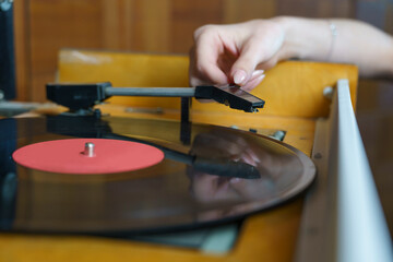 vintage romantic photo, a woman's hand plays a vinyl record, retro music