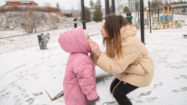 Mom with daughter spend time on fresh air on winter day in the park - Powered by Adobe