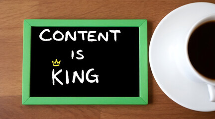 Black chalkboard with the words content is king written in white chalk and a small golden crown next to is