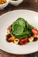 Fresh green salad with lime, strawberries, and nuts served