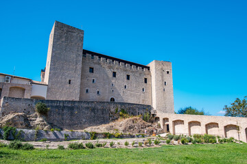 Imposing Rocca Albornoziana overlooks Spoleto from a hill, showcasing medieval architecture and fortified walls under warm sunlight in Umbria, Italy