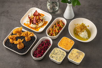 Assorted appetizers with dips, spreads, and vegetables on table
