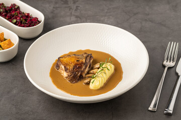 Roasted meat with mashed potatoes and brown sauce on plate