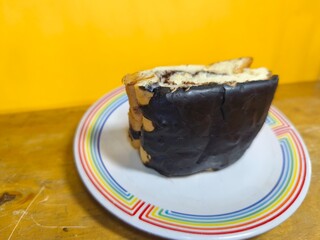 Delicious chocolate bread isolated on a yellow background. Delicious homemade dish. Stylish food for a culinary business. Close up. Copy space. Selective focus.