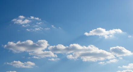 Fototapeta premium Expansive bright blue sky with soft white cumulus clouds floating peacefully on a clear sunny day, a perfect serene nature background