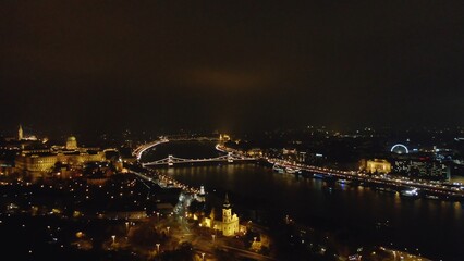 Picturesque drone view of glowing Budapest city with lights reflecting in channel in night time, Hungary
