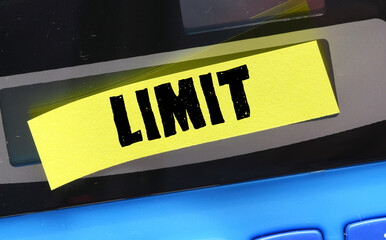 LIMIT word on a small yellow sheet of paper placed on a calculator.
