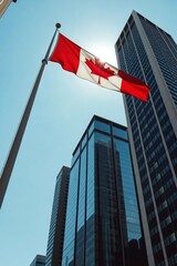 A striking, low-angle shot of the Canadian Maple Leaf flag waving majestically on a flagpole against a modern building and a clear sky.