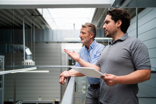 Young businessman holding tablet PC and planning with manager in factory