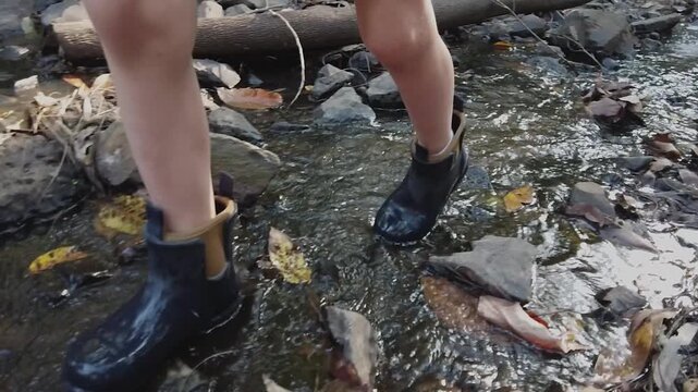 4K slow-motion of a boy’s legs in boots walking in a creek. Perfect for nature vlogs or lifestyle ads. Shot in H.264 10s. License this serene stock footage!