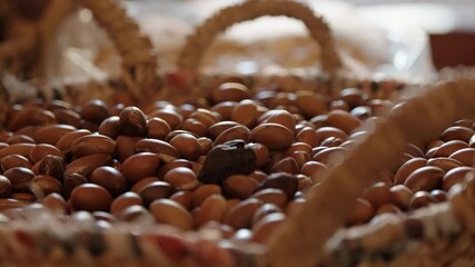 A woven basket filled with argan nuts on display at a traditional Moroccan market.