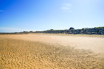 View of the beach near Sangatte on the coast in northern France. Nature by the sea with blue sky and golden sand.
