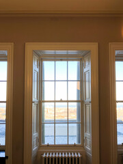 Fototapeta premium A window with a view of the city. The window is open. There is a radiator in front of the window