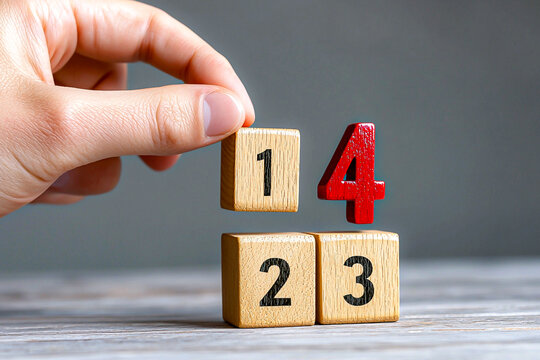 Hand Arranging Numbered Wooden Blocks on a Table
