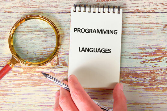 Business, programming, interface, application and network concept. Text PROGRAMMING LANGUAGES in a notebook against the background of old boards