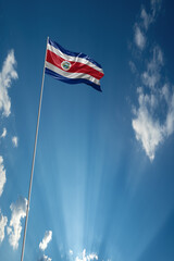Waving National flag of Costa Rica on flagpole in sky