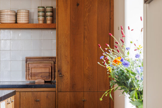 Fototapeta Detail of a wooden kitchen with flowers in the windows ill.