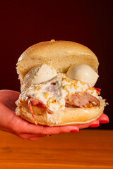 Panino da pub ripieno di hamburger di carne, mortadella piastrata, stracciata di bufala, granella di pistacchio e bocconcini di mozzarella servito in un pub