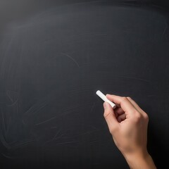 Hand holding white chalk ready to write on a dark textured chalkboard blackboard writing