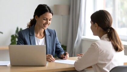 Obraz premium Smiling businesswoman in blue blazer takes notes during meeting with client