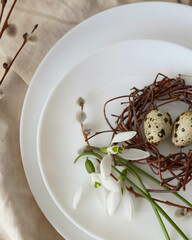 Minimal Easter Nest with Quail Eggs and Spring Flowers on White Plate