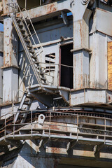 Rusty industrial structure with staircase and open doorway in bright daylight