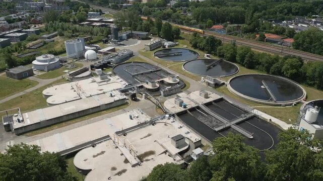 Drone footage of a modern water treatment facility with circular basins and infrastructure, symbolizing sustainability, environment, and clean water management.