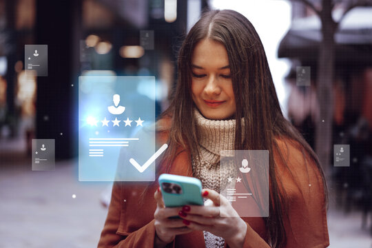 Young woman interacts with mobile phone displaying digital reviews in urban setting during evening hours