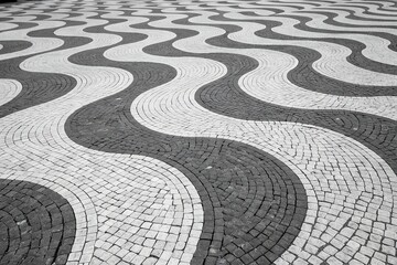 Abstract black and white wavy pattern of cobblestone pavement creating a mesmerizing optical illusion