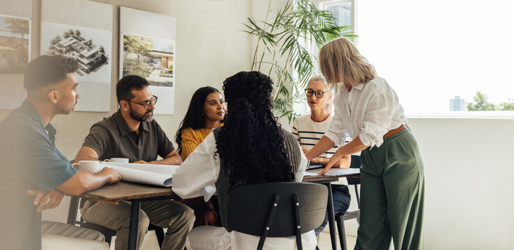 Team of diverse architects discussing a project in a modern office space