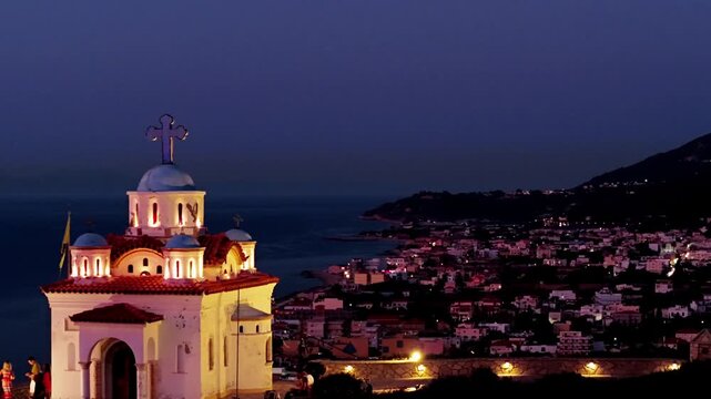 Illuminated Holy Trinity Orthodox Church with Seaside Town of Karlovasi at Twilight