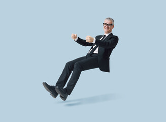 Happy corporate businessman driving an invisible car