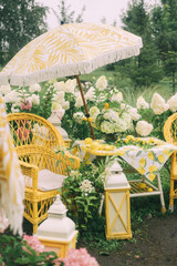 Obraz premium Lemon Themed Outdoor Garden Party with Yellow Wicker Furniture and Floral Arrangements