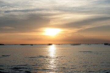 Fototapeta premium sunset in the sea. Beautiful colorful sky and cloud in twilight time background. Orange fluffy clouds and sun sunlight reflection in the blue sky.