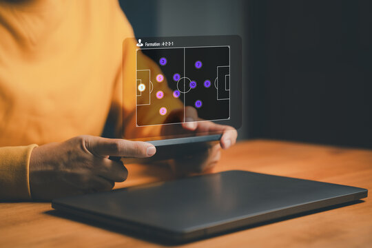 User holding a smartphone displaying a virtual soccer formation 4-2-3-1 with player icons. This concept represents strategy planning, team management and digital sports analytics in modern football. - Powered by Adobe