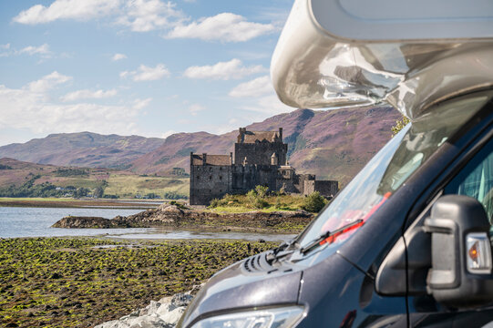 Epic road trip through Scotland: motorhome parked with breathtaking view of Eilean Donan Castle and the Highlands in the background