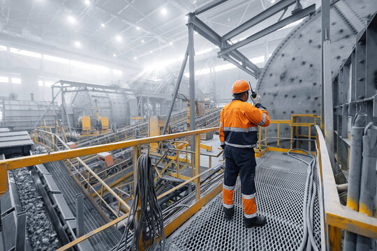 Professional heavy industry engineer worker control industrial ball mill grinds ore at mining and concentrating plant. Metal manufacture factory concentrate of copper and gold
