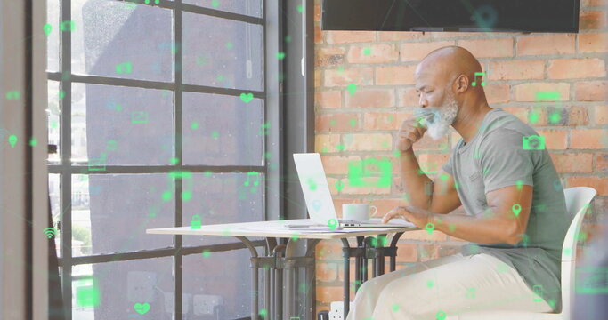 Browsing bearded man checking laptop while sipping coffee at cafe, with icon overlays, copy space