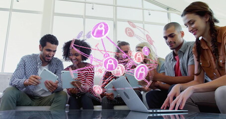 Six professionals on office sofa using tablets, laptop by glass coffee table under network overlay