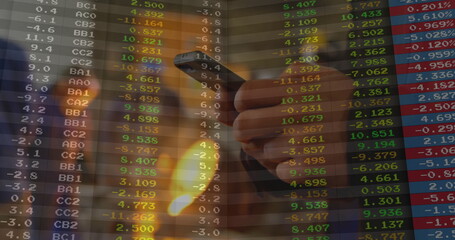 Gripping male hand tracking live stock market data on smartphone at office desk, finance theme