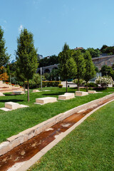 Obraz premium Tranquil landscape with manicured greenery and a gentle water feature in a serene park setting