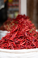 Fototapeta premium Red chilli pepper spices for sale on a spice market in India, fresh ingredients for cooking indian spicy food masala