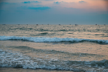 Fototapeta premium Sunset at Colva Goa beach in South India, silhouette of boats, tropical west coast, Arabian Sea in Asia, vacation destination