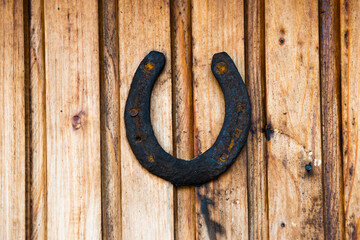 Old rustic horseshoe on wooden wall. Rust horse shoe for luck
