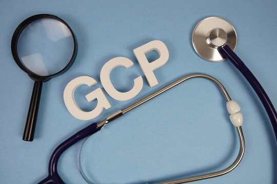 GCP abbreviation of Good Clinical Practices alphabet letters with magnifying glass and stethoscope on blue background - Powered by Adobe